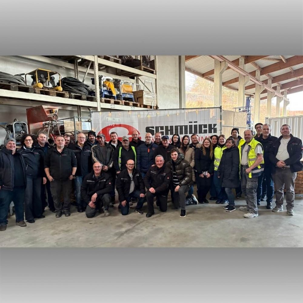 Das SCHMÜCK-Team feiert das traditionelle Weihnachtsgrillen auf dem Bauhof in Bad Kissingen: Mitarbeiter beim Jahresabschlussgrillen mit Glühwein und festlicher Stimmung für erholsame Feiertage.