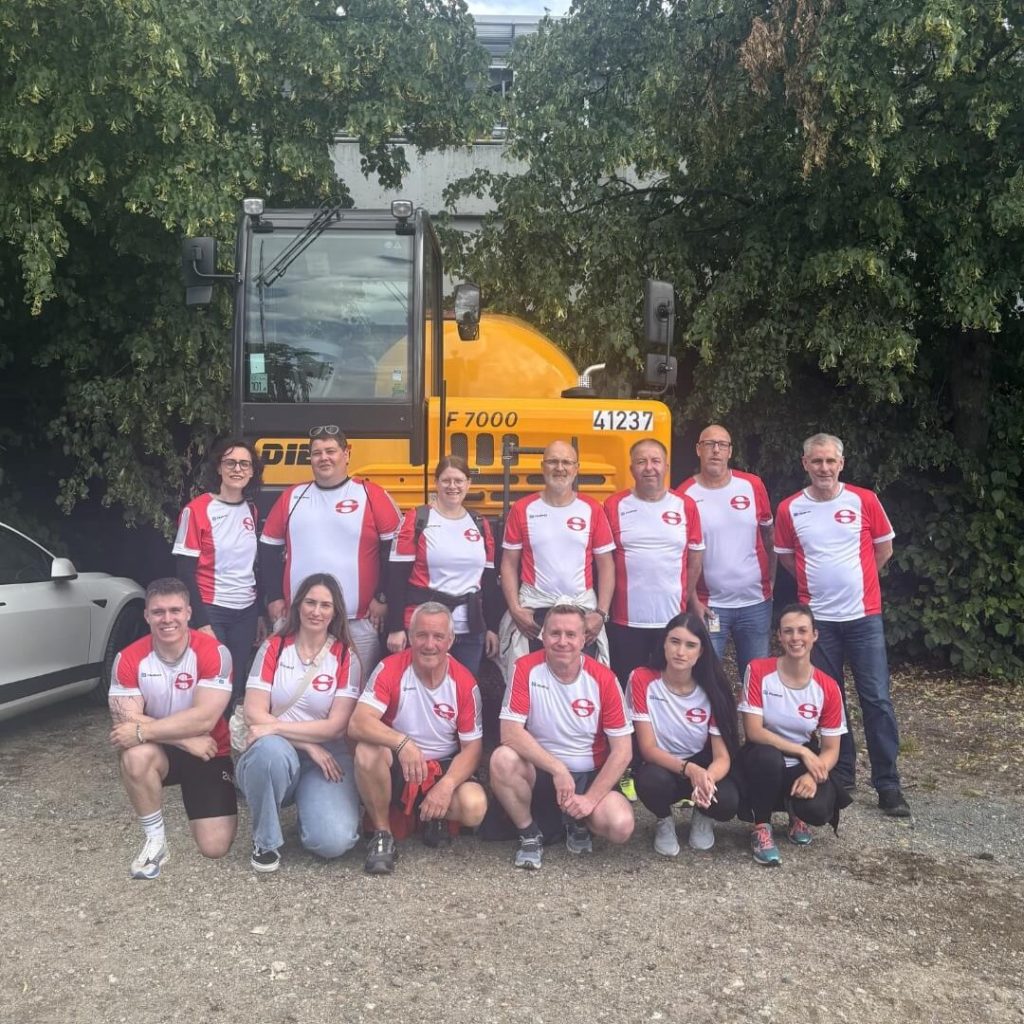 Team von Schmück in firmeneigenen Lauftrikots vor einem Schmück-Betonmischer bei der JPMorganChase Corporate Challenge 2026 in Frankfurt